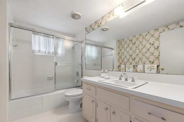 full bathroom featuring tile patterned floors, vanity, toilet, and enclosed tub / shower combo