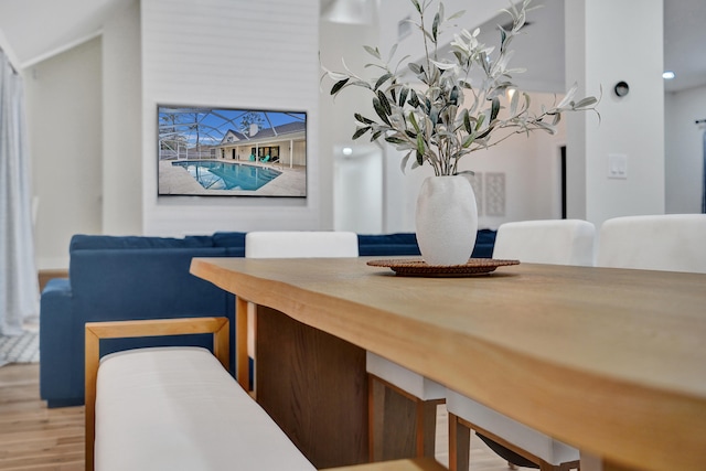 dining area with hardwood / wood-style flooring and vaulted ceiling