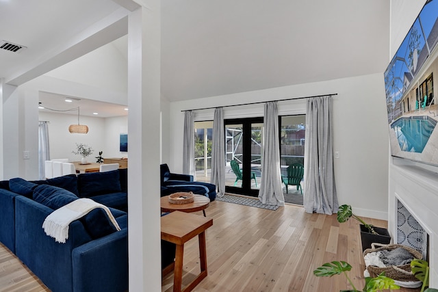 living room with french doors and light wood-type flooring