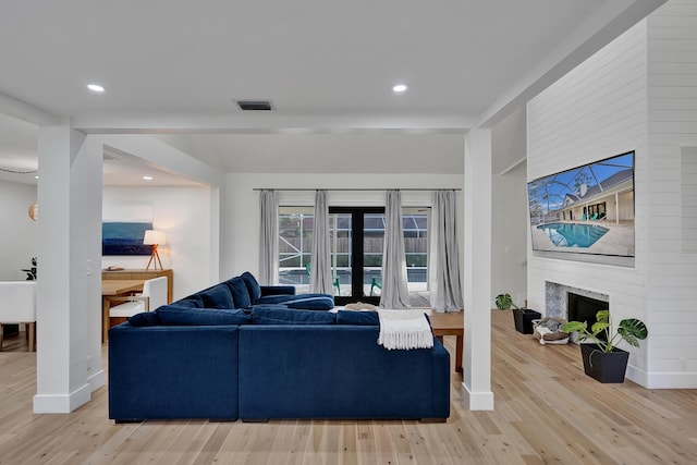 living room featuring light wood-type flooring and a fireplace