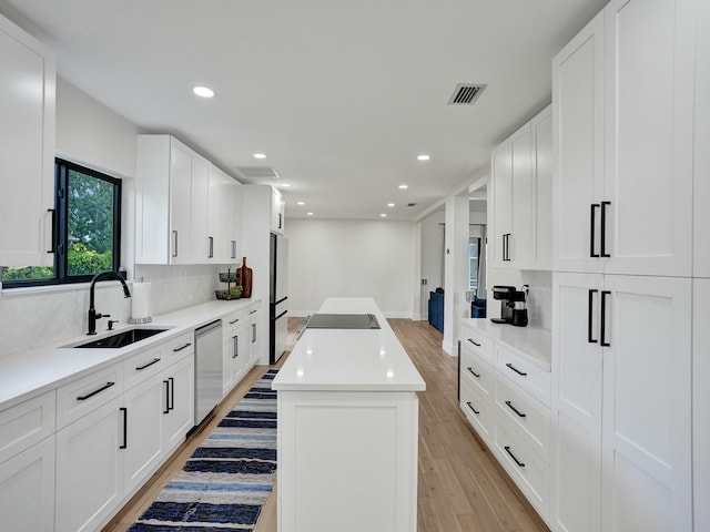 kitchen with white cabinetry, dishwasher, a center island, and sink