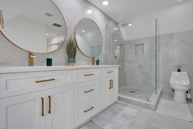 bathroom with vanity, a tile shower, tile patterned floors, and toilet