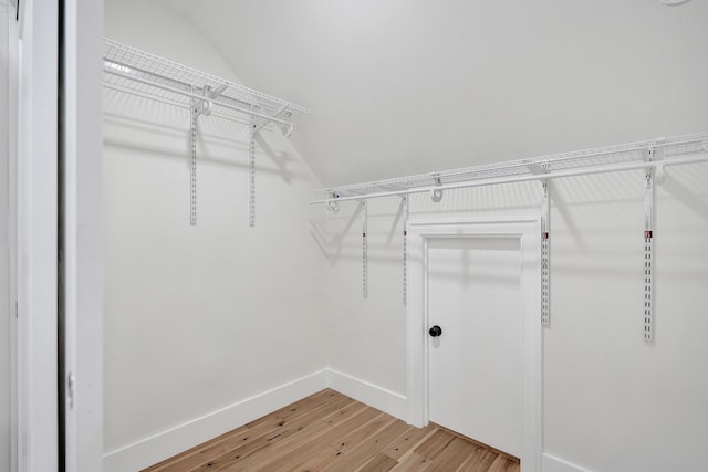 spacious closet featuring lofted ceiling and hardwood / wood-style flooring