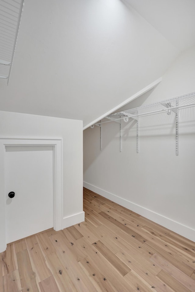 spacious closet with lofted ceiling and light wood-type flooring