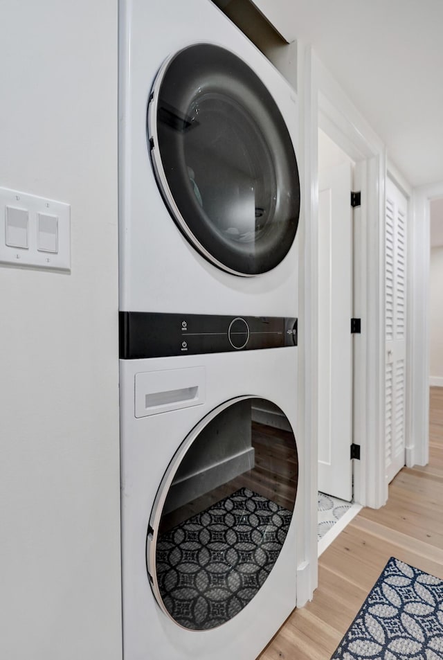 washroom featuring stacked washer and clothes dryer and hardwood / wood-style floors