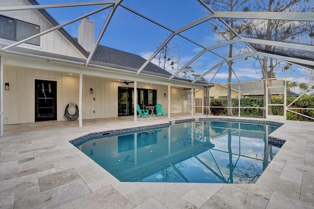 view of swimming pool with a patio area, ceiling fan, and glass enclosure