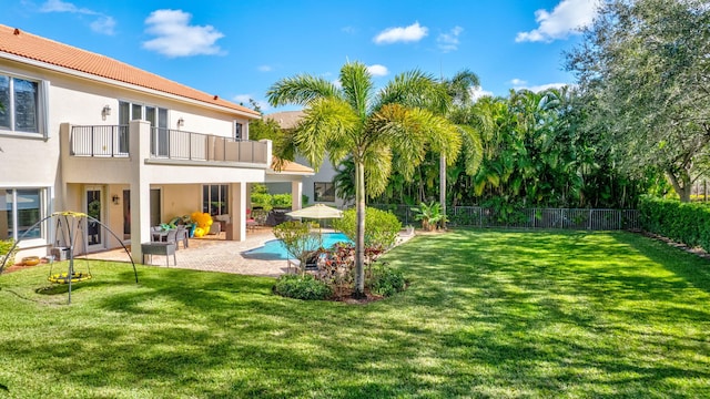 view of yard with a fenced in pool, an outdoor living space, a patio area, and a balcony