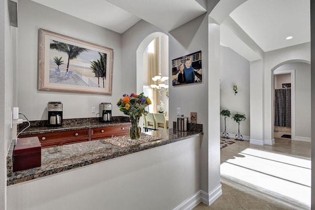 bar featuring light tile patterned floors and dark stone counters