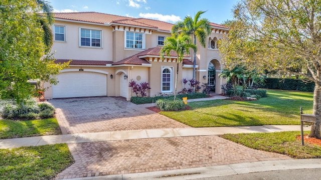 mediterranean / spanish-style home featuring a garage and a front lawn