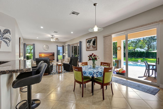 tiled dining area featuring a textured ceiling