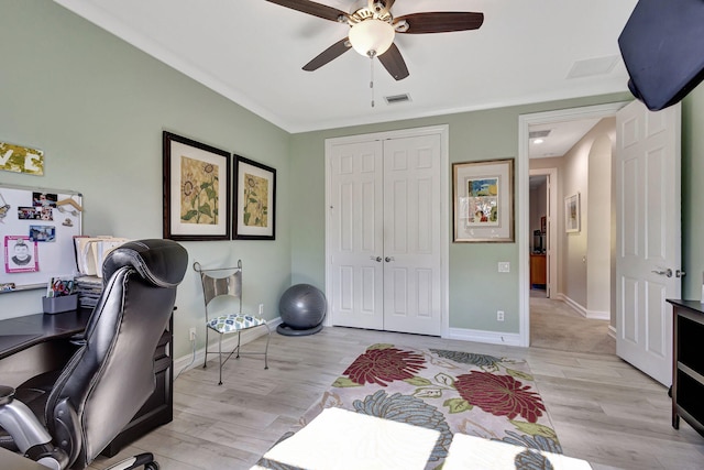 home office with light hardwood / wood-style floors and ceiling fan