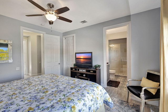 bedroom featuring ceiling fan, hardwood / wood-style floors, and ensuite bath