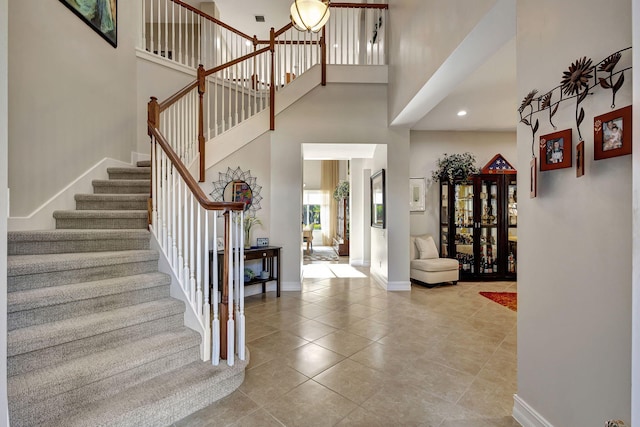 entrance foyer with tile patterned flooring and a towering ceiling