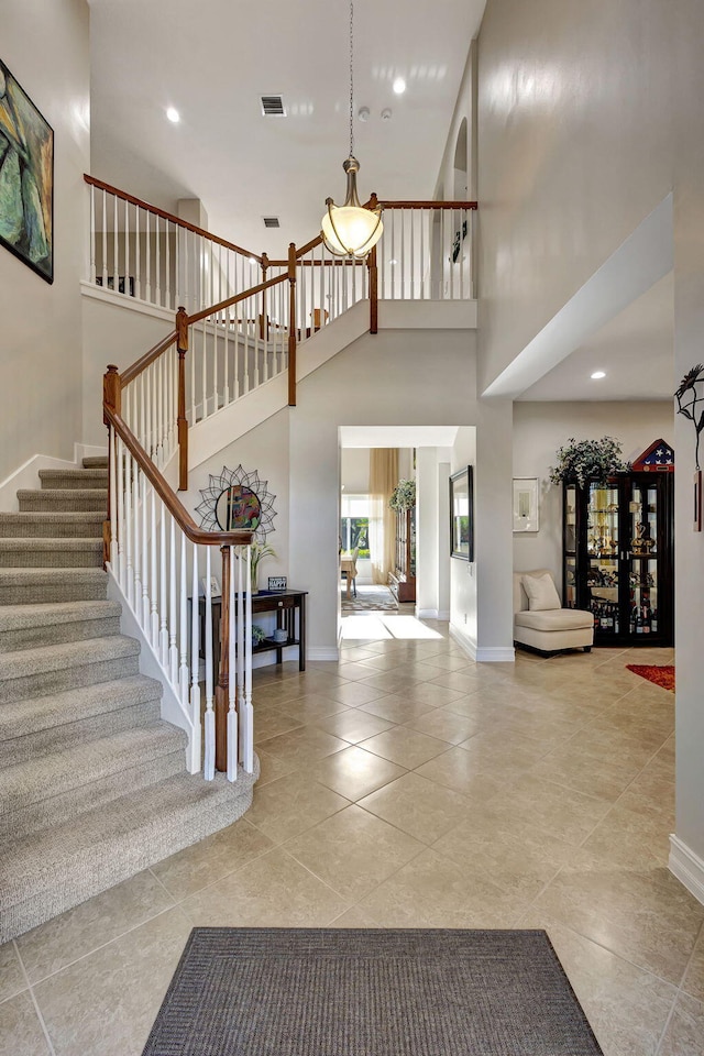 foyer featuring a towering ceiling and light tile patterned floors