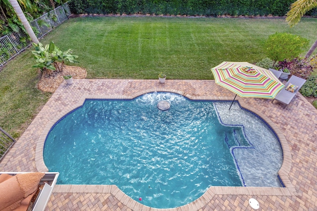 view of swimming pool with a lawn