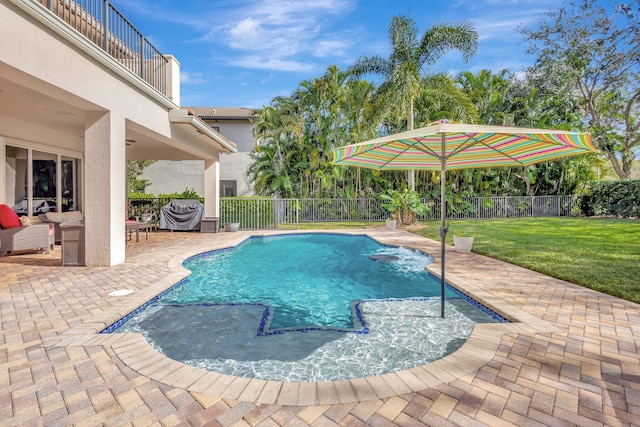 view of pool with a patio and a lawn