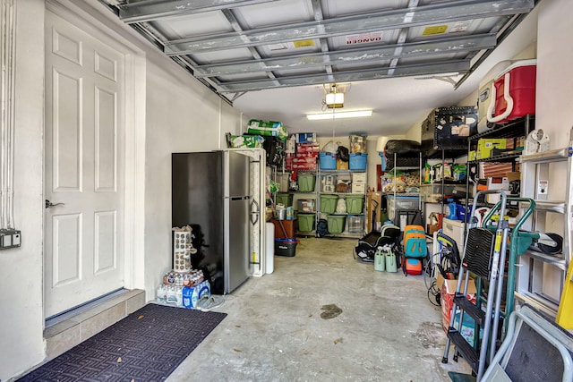 garage featuring a garage door opener and stainless steel fridge