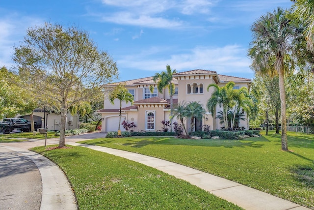 mediterranean / spanish-style home featuring a garage and a front lawn