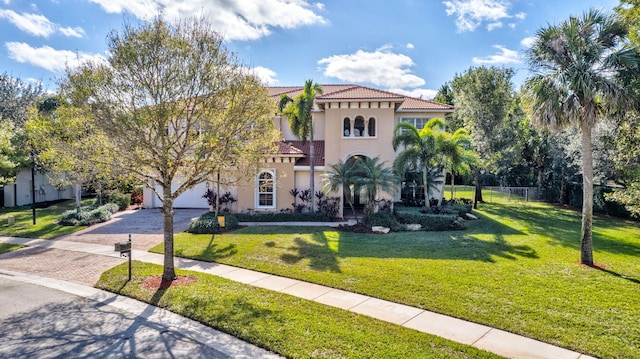 mediterranean / spanish house with a garage and a front yard