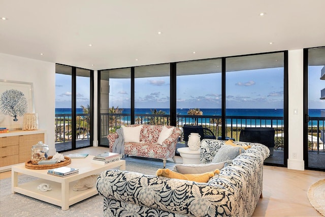 living room with a water view and a wall of windows