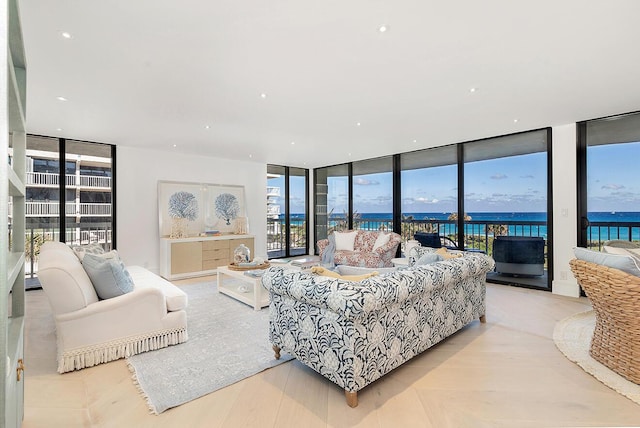 living room with a wall of windows, a water view, and plenty of natural light