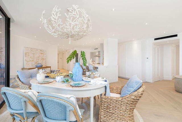 dining room featuring a chandelier and light parquet flooring