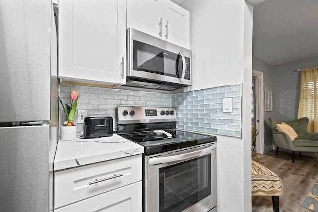 5219 NE 20th Ter, Pompano Beach, FL 33064 - kitchen featuring white cabinets, backsplash, appliances with stainless steel finishes, and wood finished floors