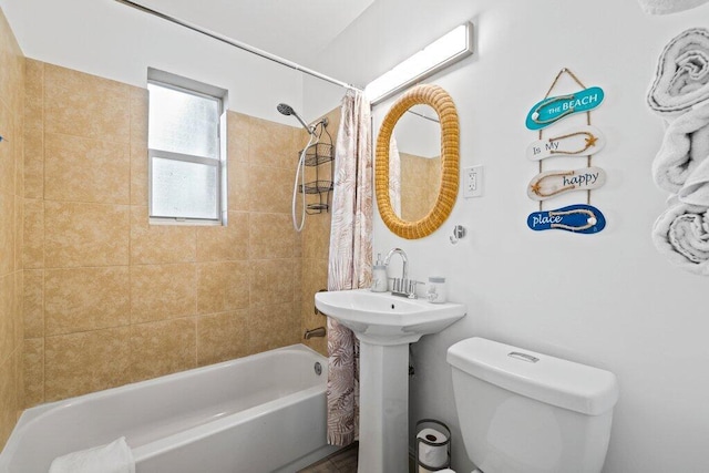 full bathroom featuring toilet, sink, and shower / bath combo with shower curtain