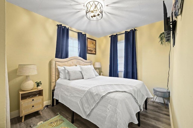 bedroom with an inviting chandelier and dark hardwood / wood-style flooring