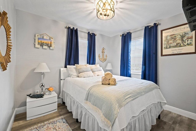 bedroom featuring dark wood-type flooring and a notable chandelier