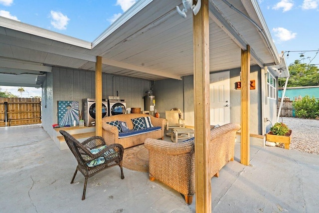 view of patio / terrace with outdoor lounge area, electric water heater, and washing machine and clothes dryer