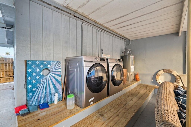 clothes washing area with separate washer and dryer and water heater