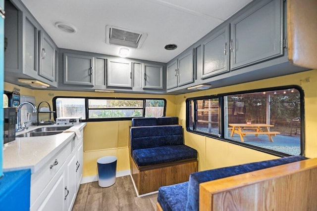 interior space featuring gray cabinets, sink, and light hardwood / wood-style flooring