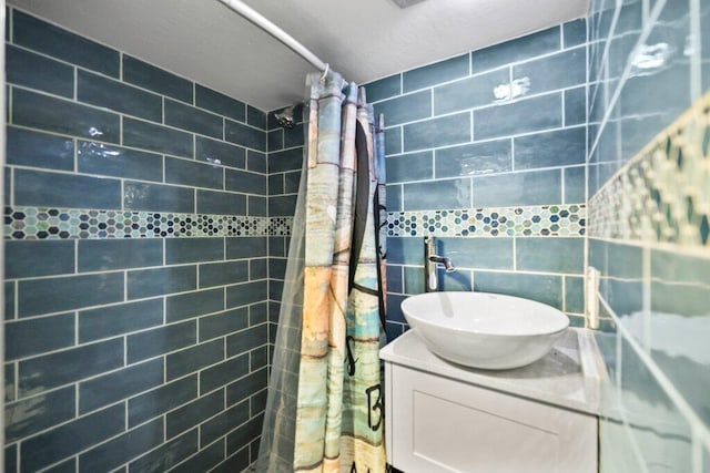 bathroom featuring a shower with shower curtain, sink, and tile walls