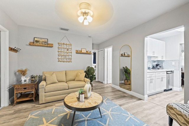5219 NE 20th Ter, Pompano Beach, FL 33064 - living area featuring light wood-type flooring, visible vents, baseboards, and ceiling fan