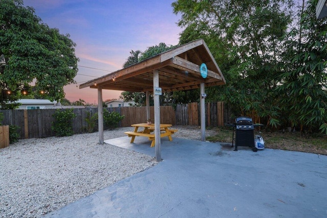 patio terrace at dusk featuring area for grilling