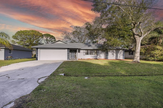 single story home with a garage and a lawn