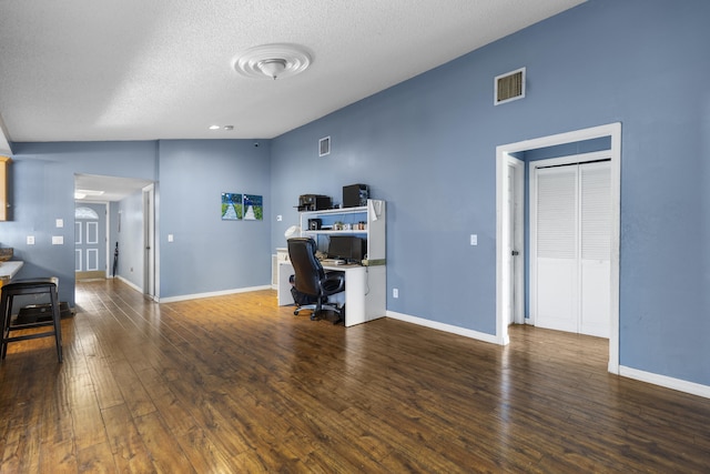 office with dark hardwood / wood-style floors and a textured ceiling