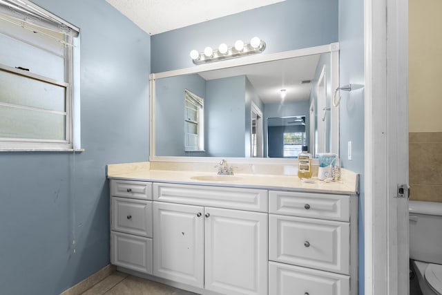 bathroom featuring toilet, vanity, tile patterned floors, and a textured ceiling