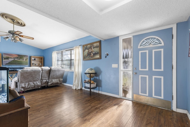 entrance foyer with ceiling fan, vaulted ceiling, dark hardwood / wood-style floors, and a textured ceiling