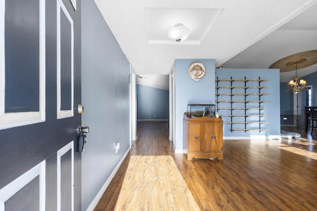 entryway with wood-type flooring and an inviting chandelier