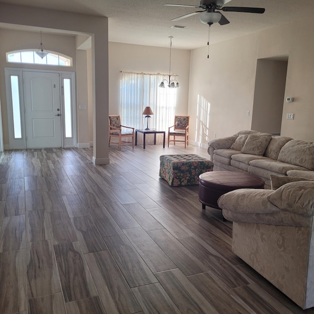 living room featuring ceiling fan with notable chandelier