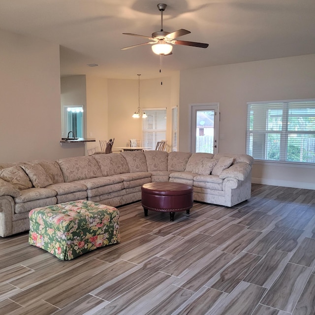 living room with ceiling fan with notable chandelier