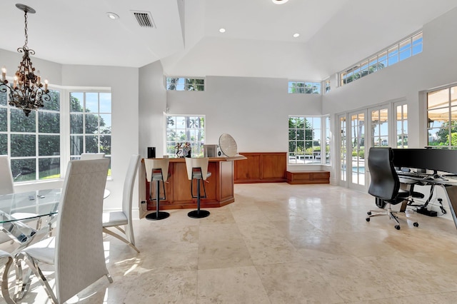 office with french doors, a towering ceiling, and an inviting chandelier