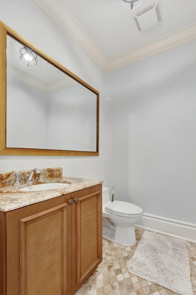 bathroom featuring toilet, vanity, and crown molding