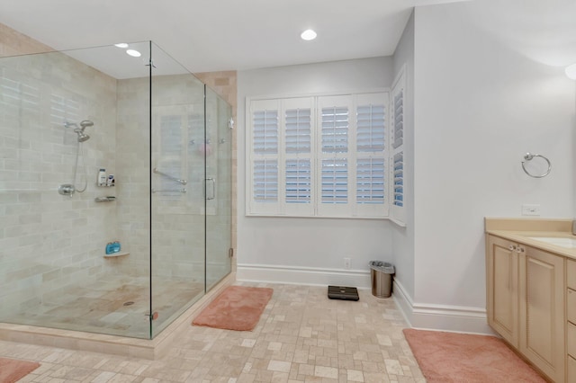 bathroom with a shower with shower door and vanity