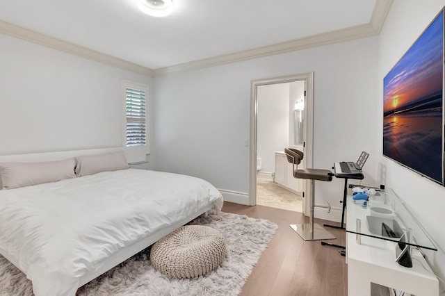 bedroom with ornamental molding, connected bathroom, and light hardwood / wood-style flooring