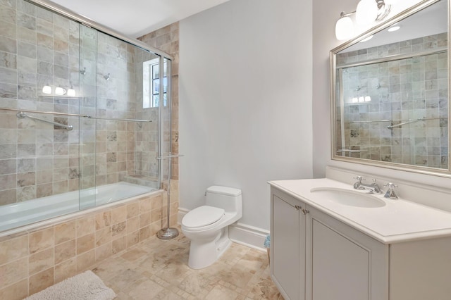 full bathroom featuring toilet, bath / shower combo with glass door, and vanity