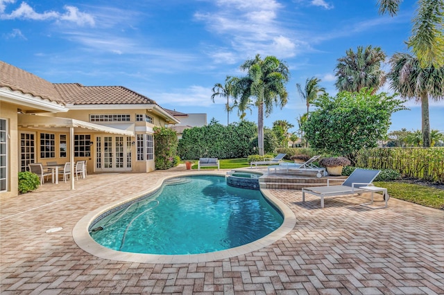 view of swimming pool featuring french doors, an in ground hot tub, and a patio