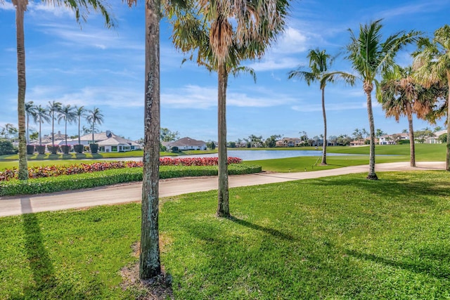 view of home's community featuring a lawn and a water view